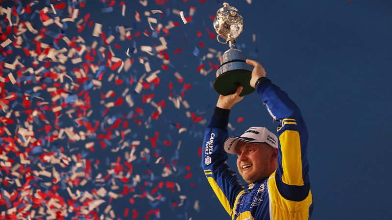 Ash Sutton holds up BTCC title trophy